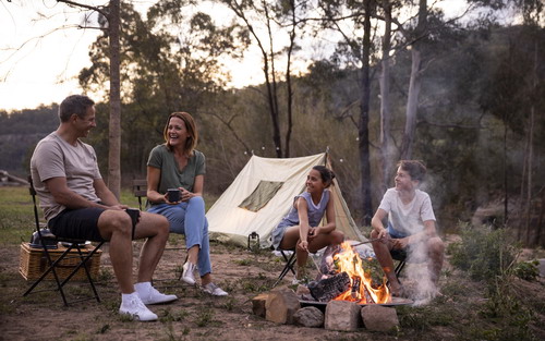 family outside tent with fire