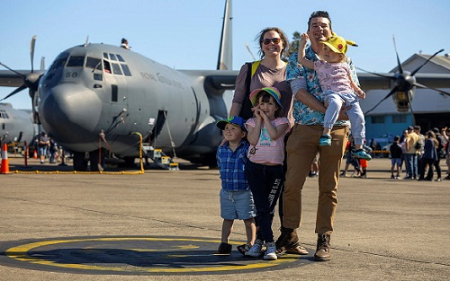 family in front of plane