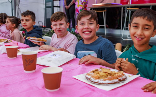 Children sitting for apple pie eating competition